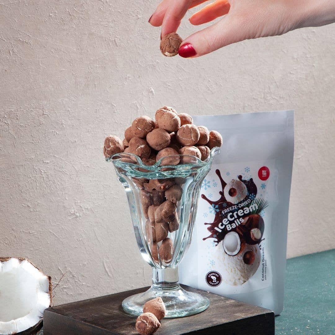 Gefriergetrocknete Eiskremkugeln Kokostraum auf hellem Hintergrund – innovativer Schweizer Snack